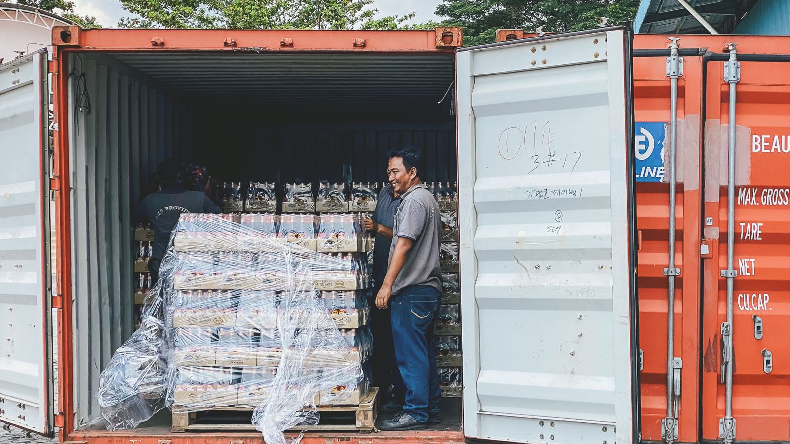 Contenedor con las puertas abiertas, cargado a medias con pallets envueltos en film: la carga de un consolidado espera a que se complete el contenedor antes de zarpar